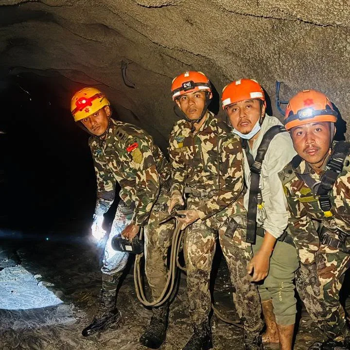 Rescue workers in helmets and headlamps in the flooded hydropower tunnel