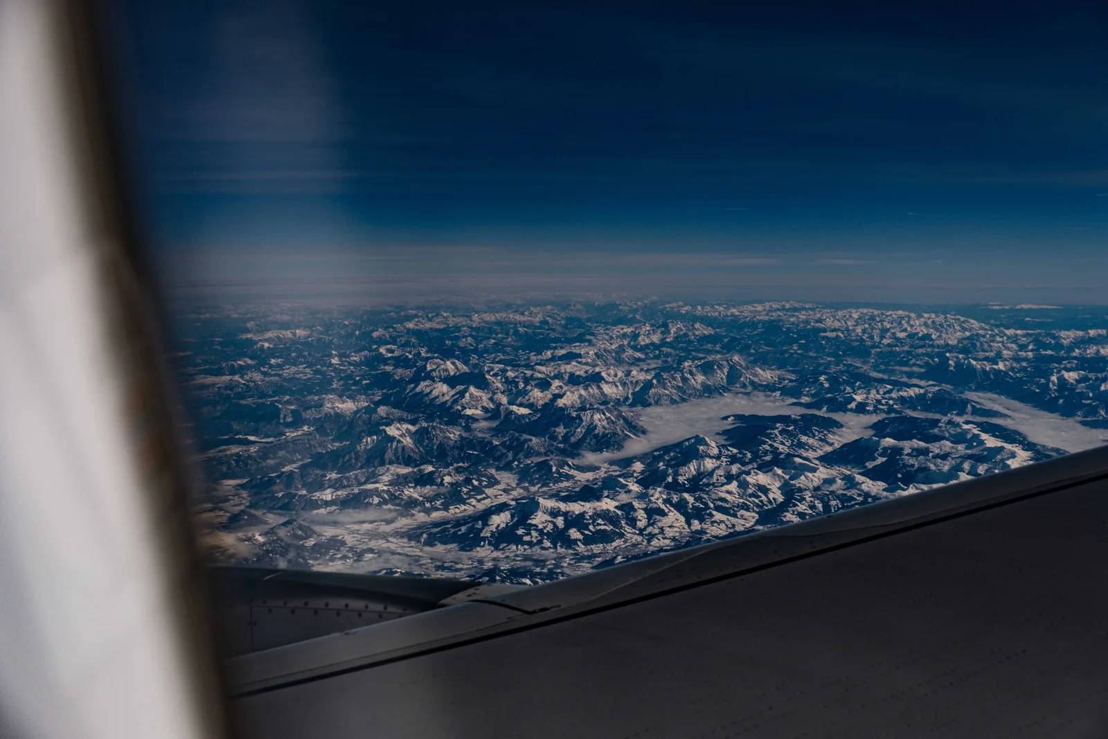 The view from an aircraft window over mountains — arriving by air is what compresses days of acclimatisation into a few hours