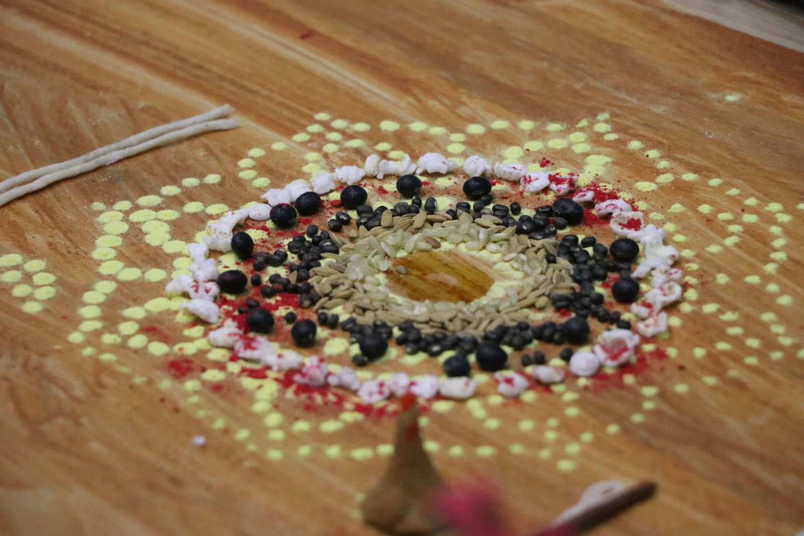 Colorful mandala with seeds and powders for Nepalese festive rituals symbolizing cultural richness.
