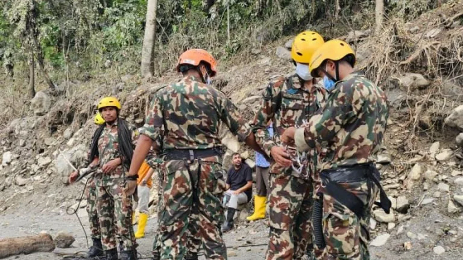Nepal Army personnel in helmets and harnesses working on a debris slope above the Upper Trishuli 3B tunnel in Nuwakot