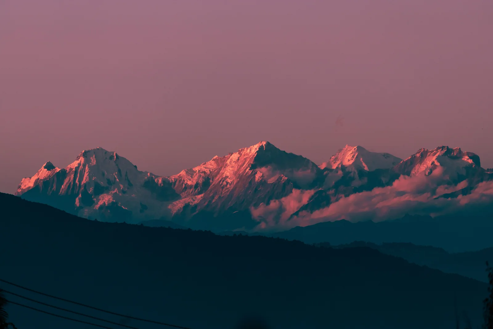 Breathtaking view of Kanchenjunga bathed in sunset hues, showcasing stunning Himalayan landscape.