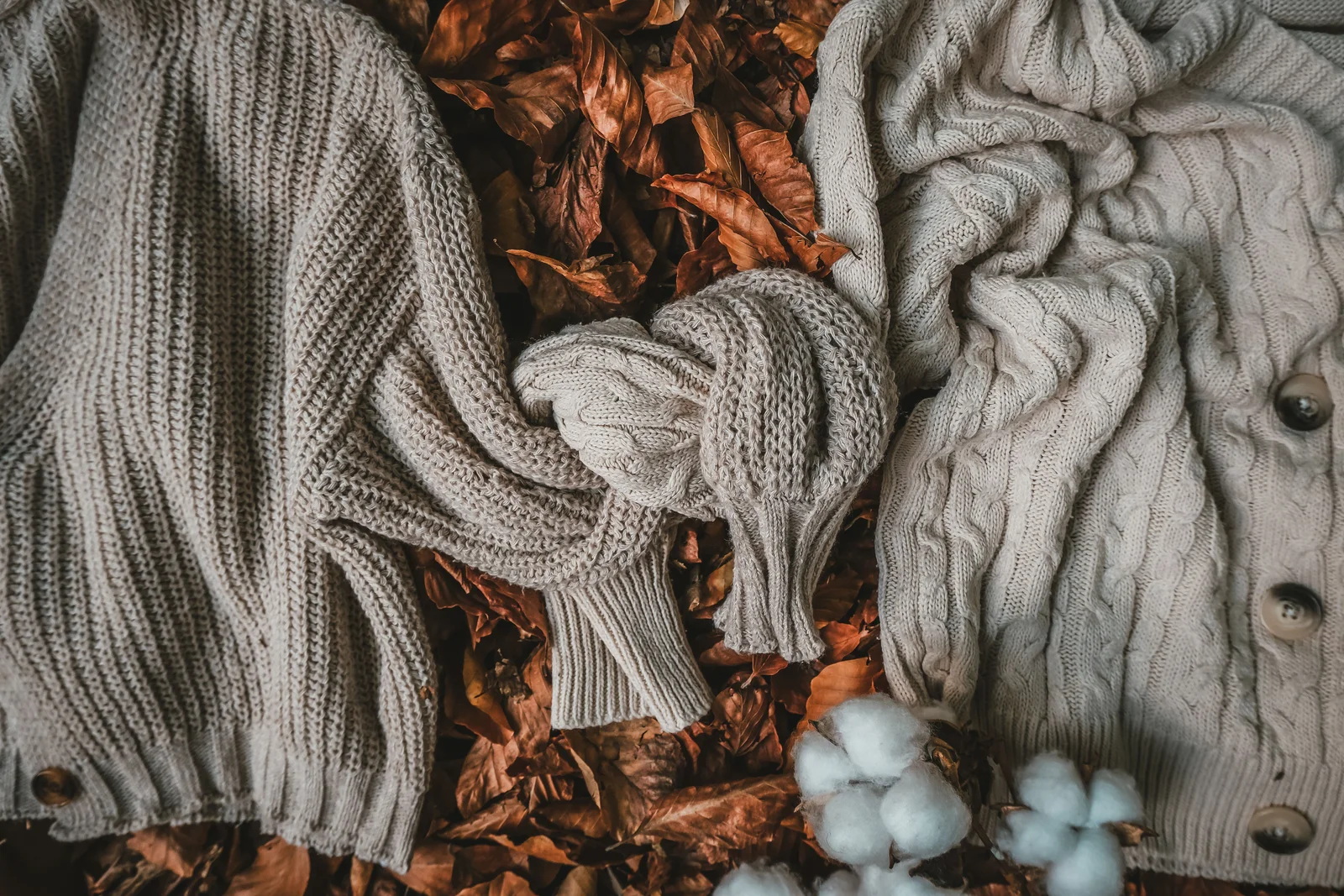 Heavy knitwear laid out on autumn leaves — warm, but nothing like the thin layer that actually goes next to the skin