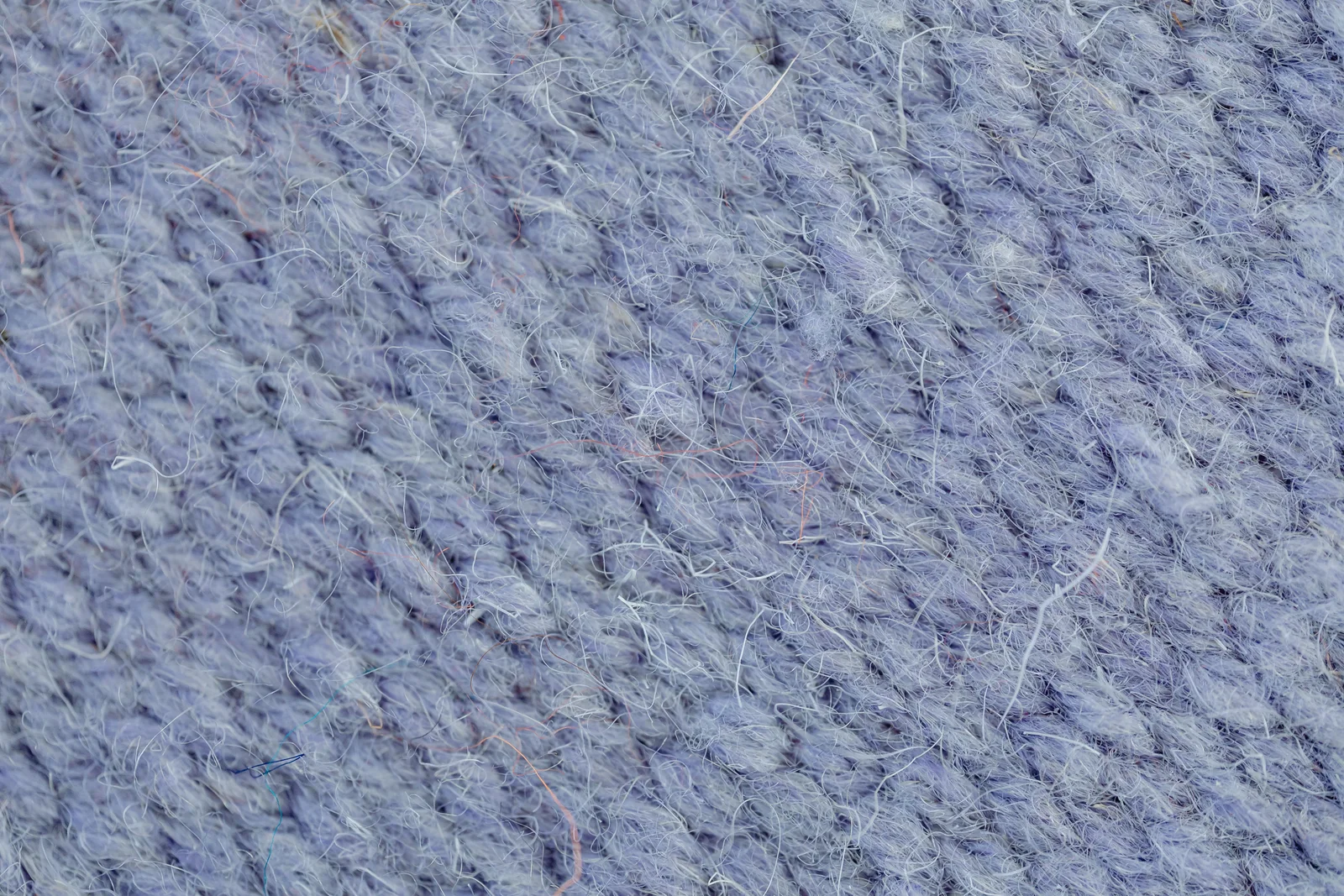 A knit fabric photographed close enough to show the loops of yarn — fibre type, not bacterial count, is what drove the odour ratings