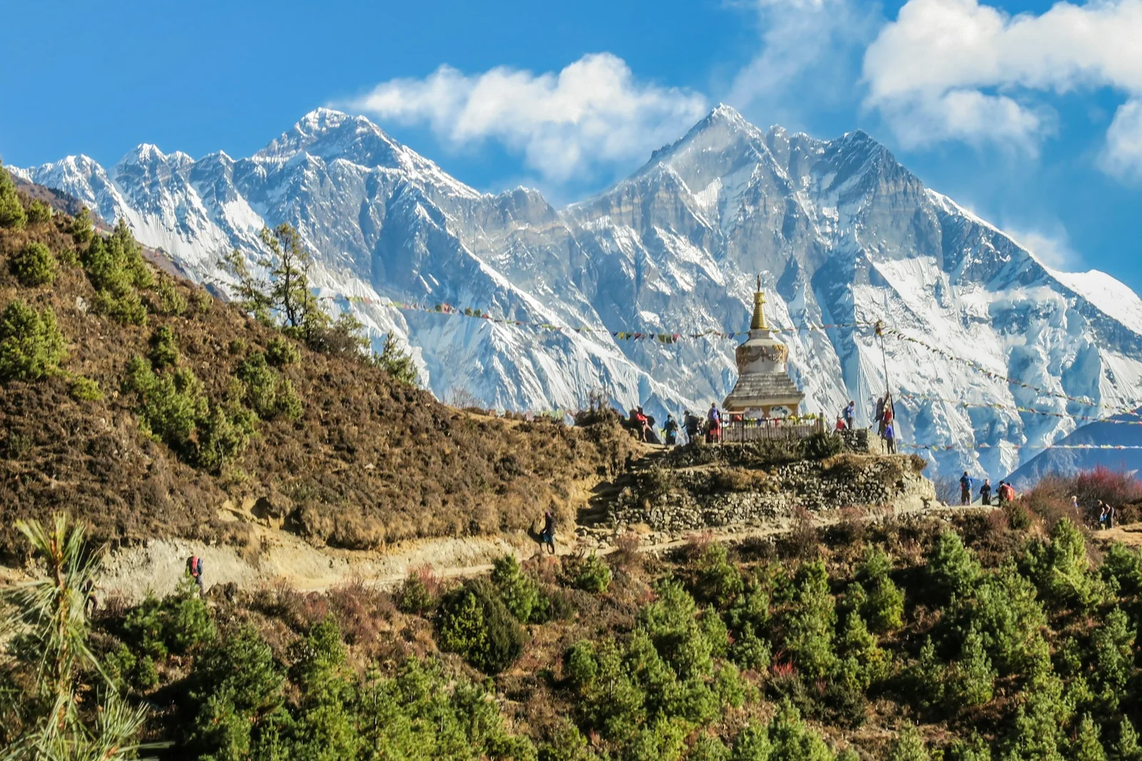 A Buddhist stupa with prayer flags before snow-capped Himalayan peaks in Nepal