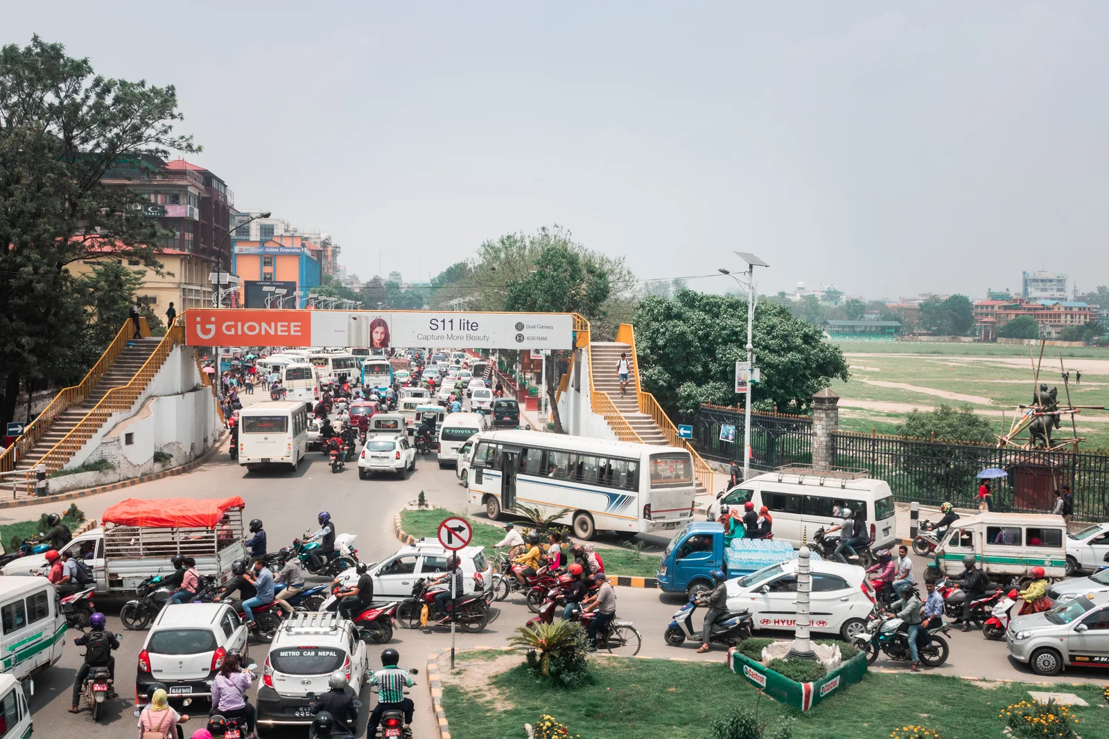 A busy urban street in Kathmandu full of cars and motorcycles, showcasing vibrant city life.