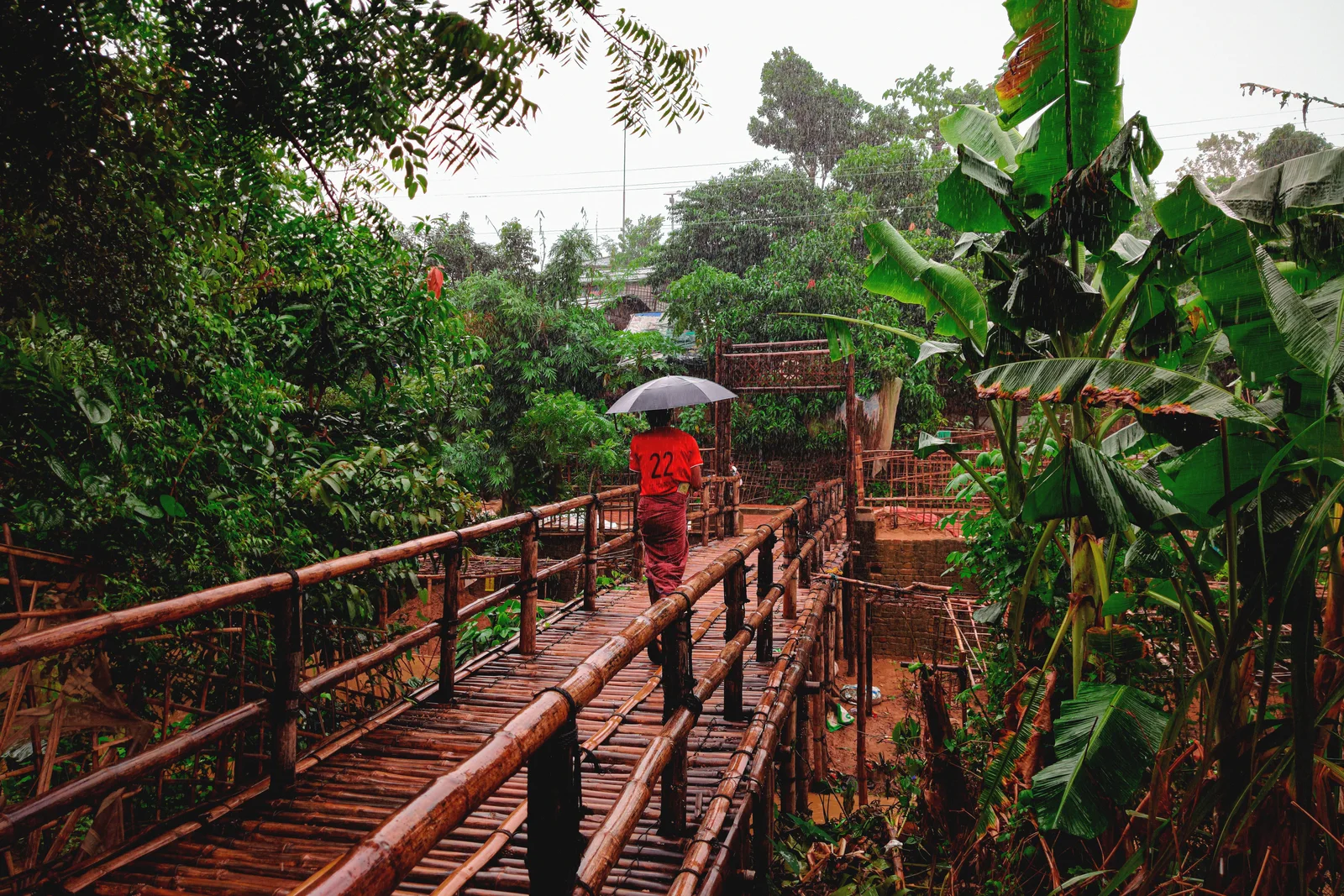 Heavy monsoon rain over green hills — days of sustained rain that no garment stays dry through