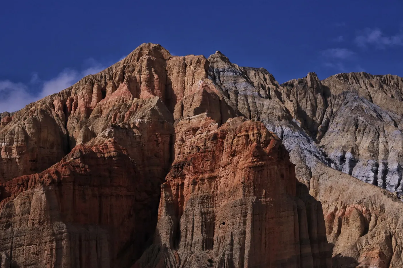 Eroded ochre cliffs and ancient cave dwellings above the Kali Gandaki in Upper Mustang